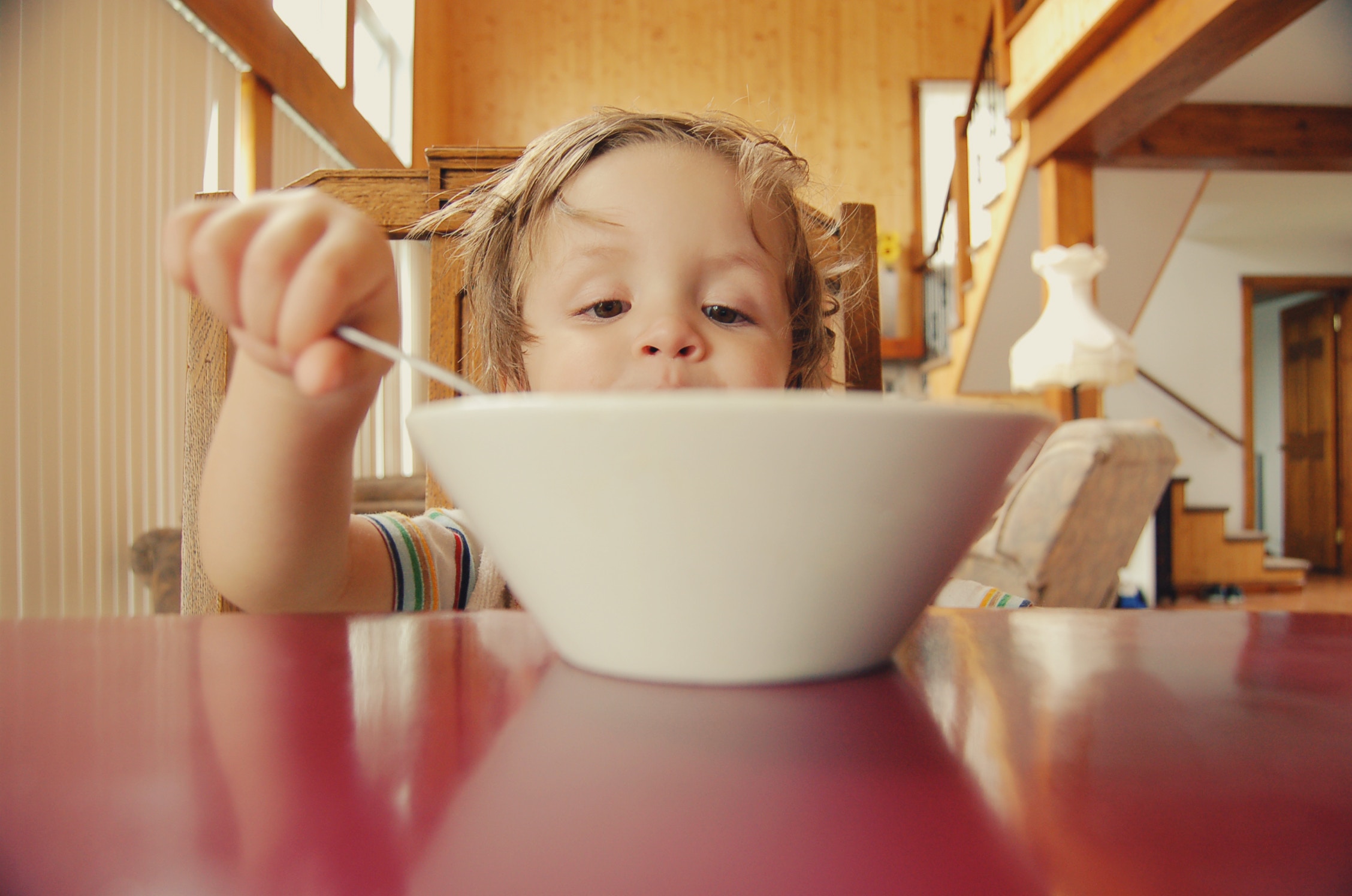 Small boy eating from a large bowl.