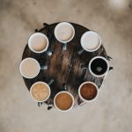 Cups of coffee on a round table in various shades due to creamer.