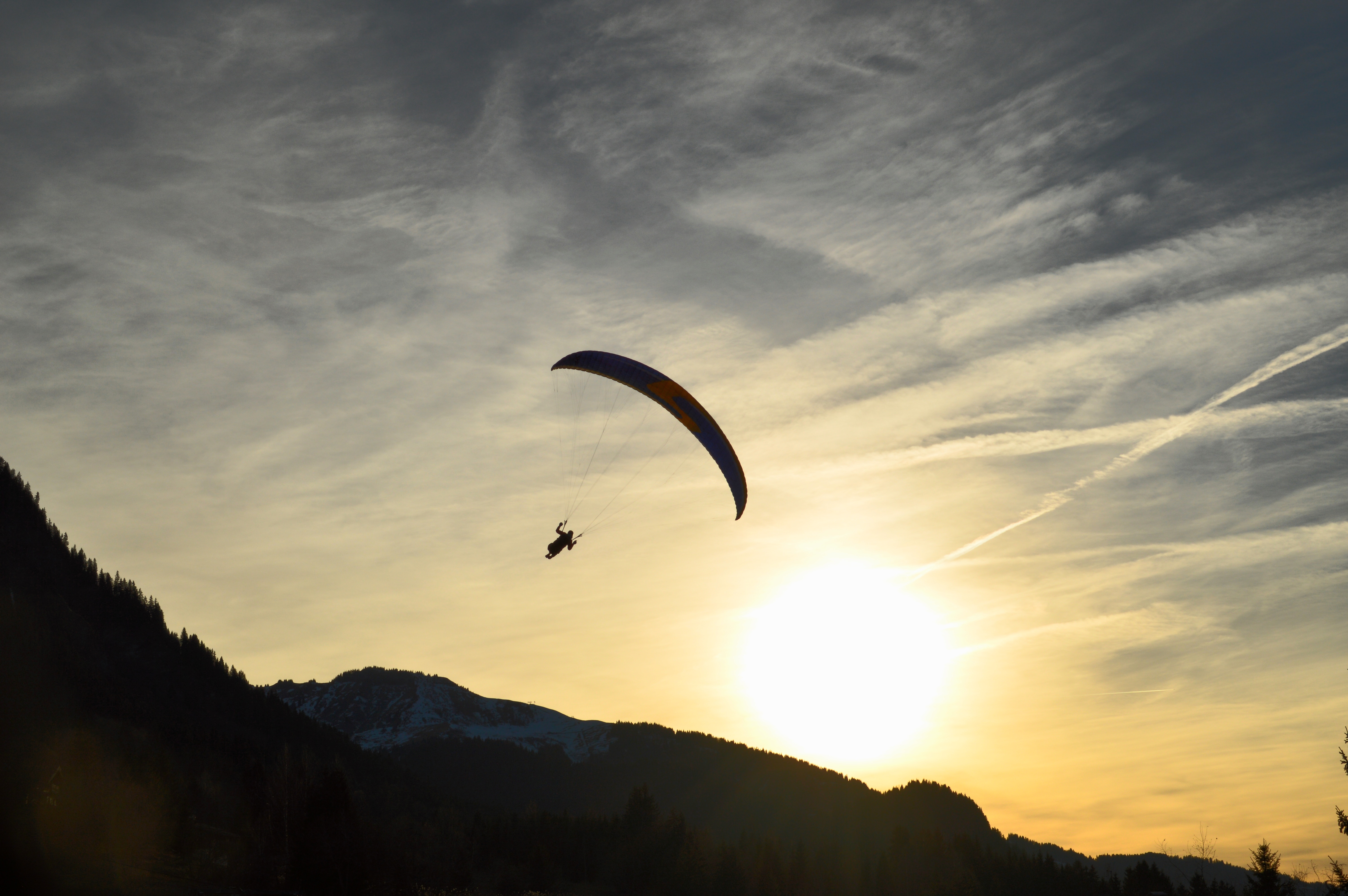 Person parachuting during a sunset.